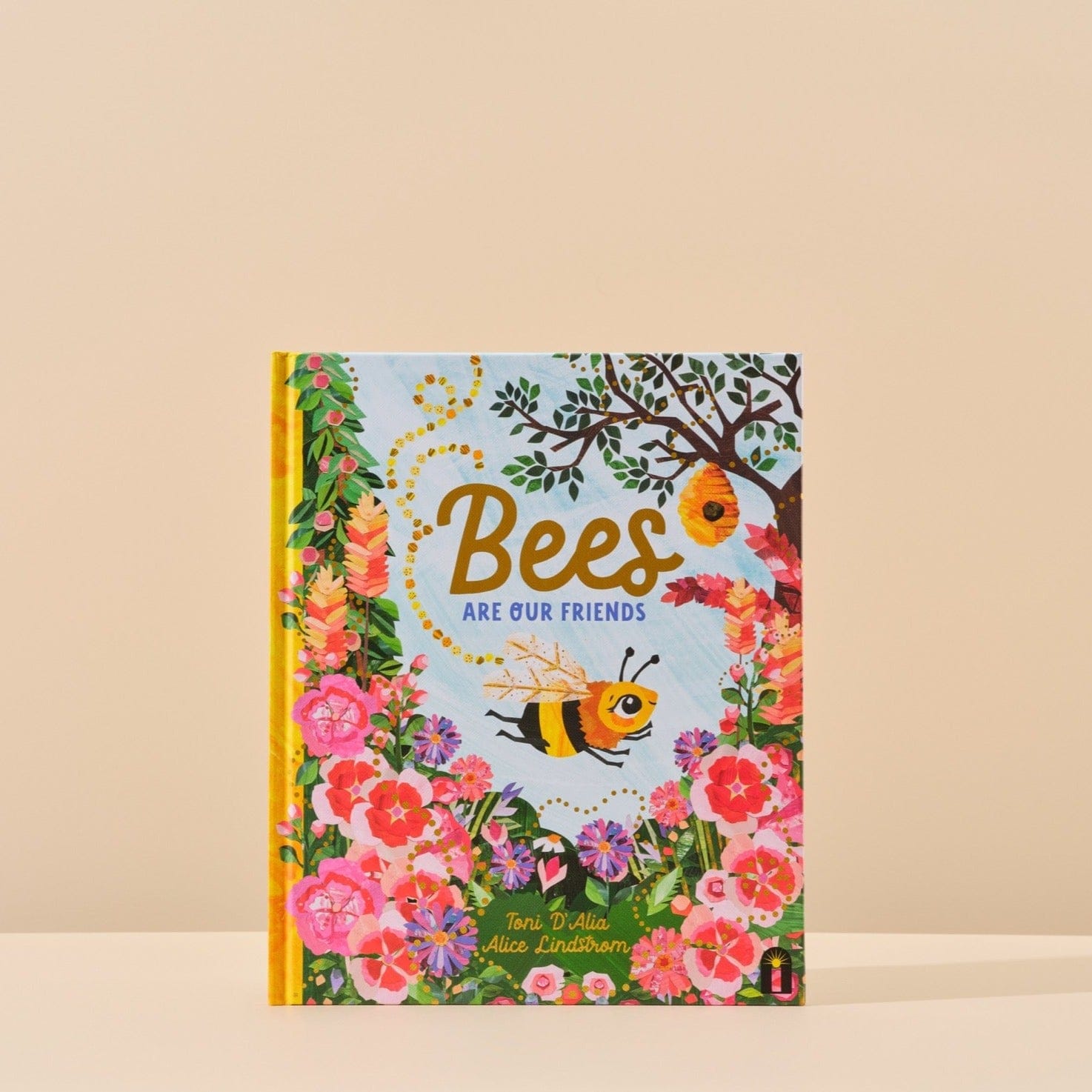 This image features the cover of Bees are our Friends written by Toni D'Alia and illustrated by Alice Lindstrom that is included in Handsel's Champagne Baby Showers gift bundle. The image is shot with a natural background. 