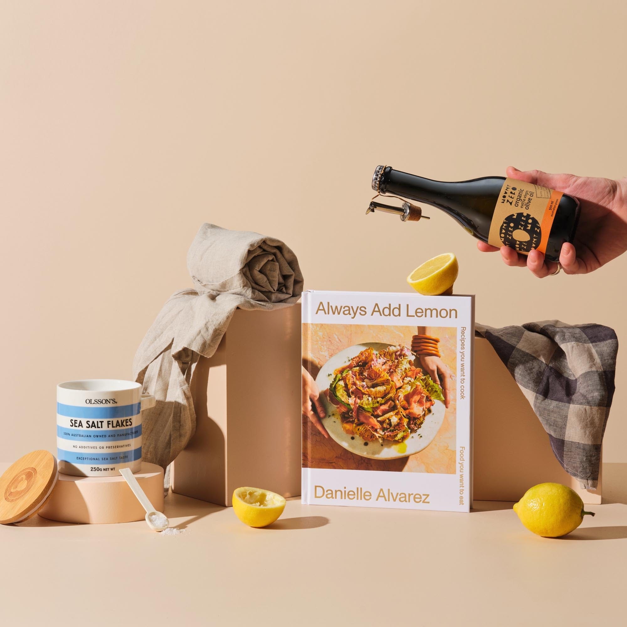 This is the Larder Love gift bundle from Handsel. Included in this image is Always Add Lemon, Olive oil, Sea salt flakes and an Apron/Tea towel